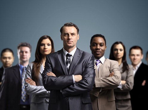 Seven business people standing whith their arms crossed in front of them.